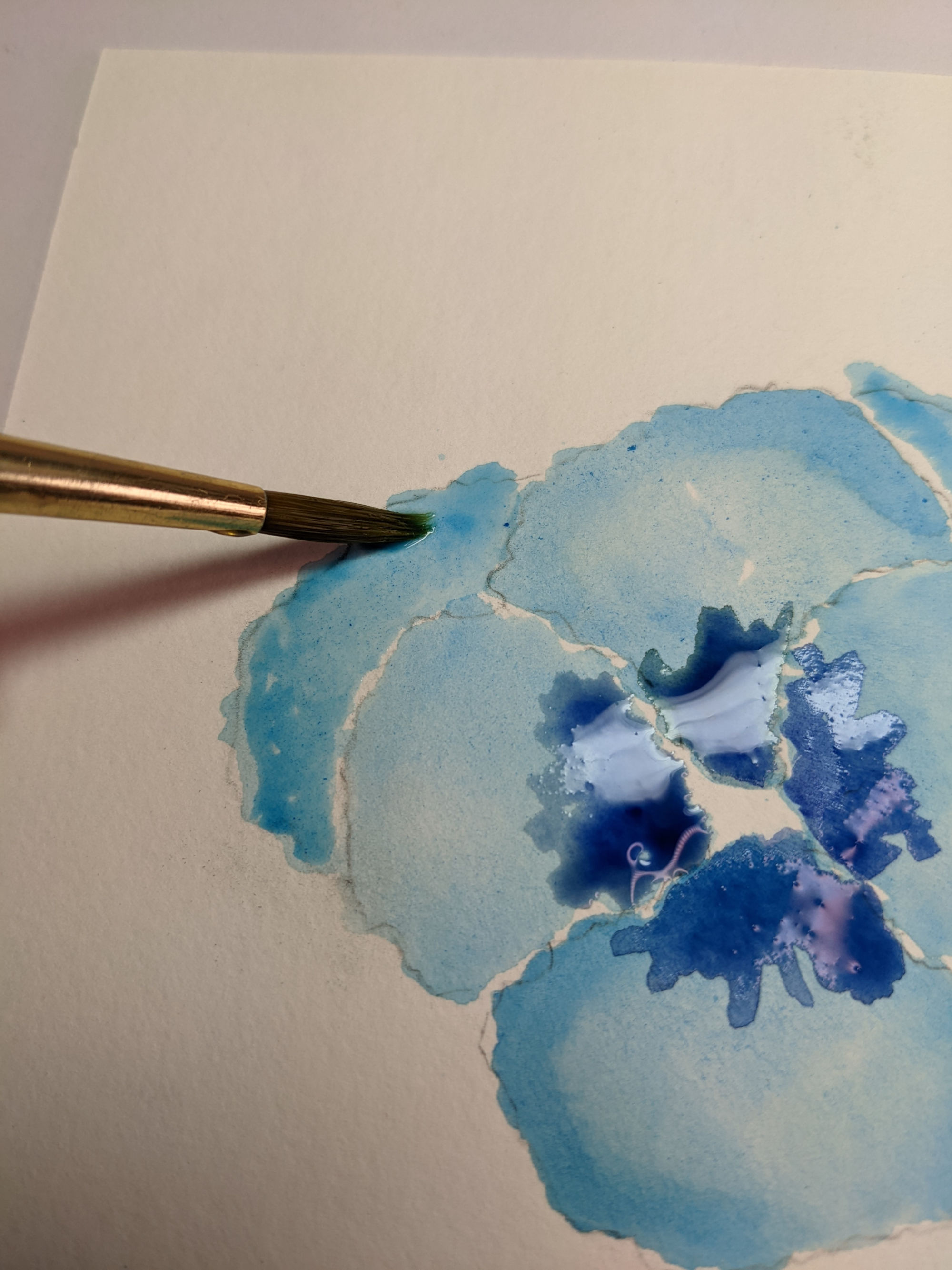 Deepening watercolor tones on a blue abstract flower painting
